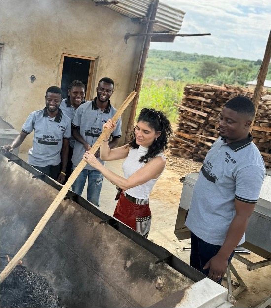 Patrícia Silva on a biochar project site with a local project team